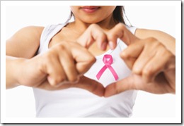 Heart framing on woman chest with pink badge to support breast cancer cause