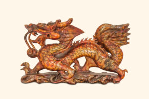 carving of elaborate wood dragon on warm background color