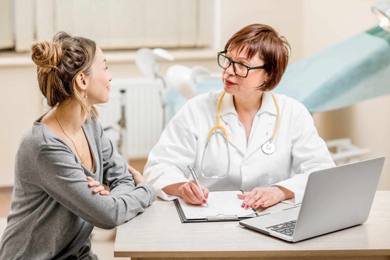Young woman patient talking with a female gynecologist during the consultation in the office